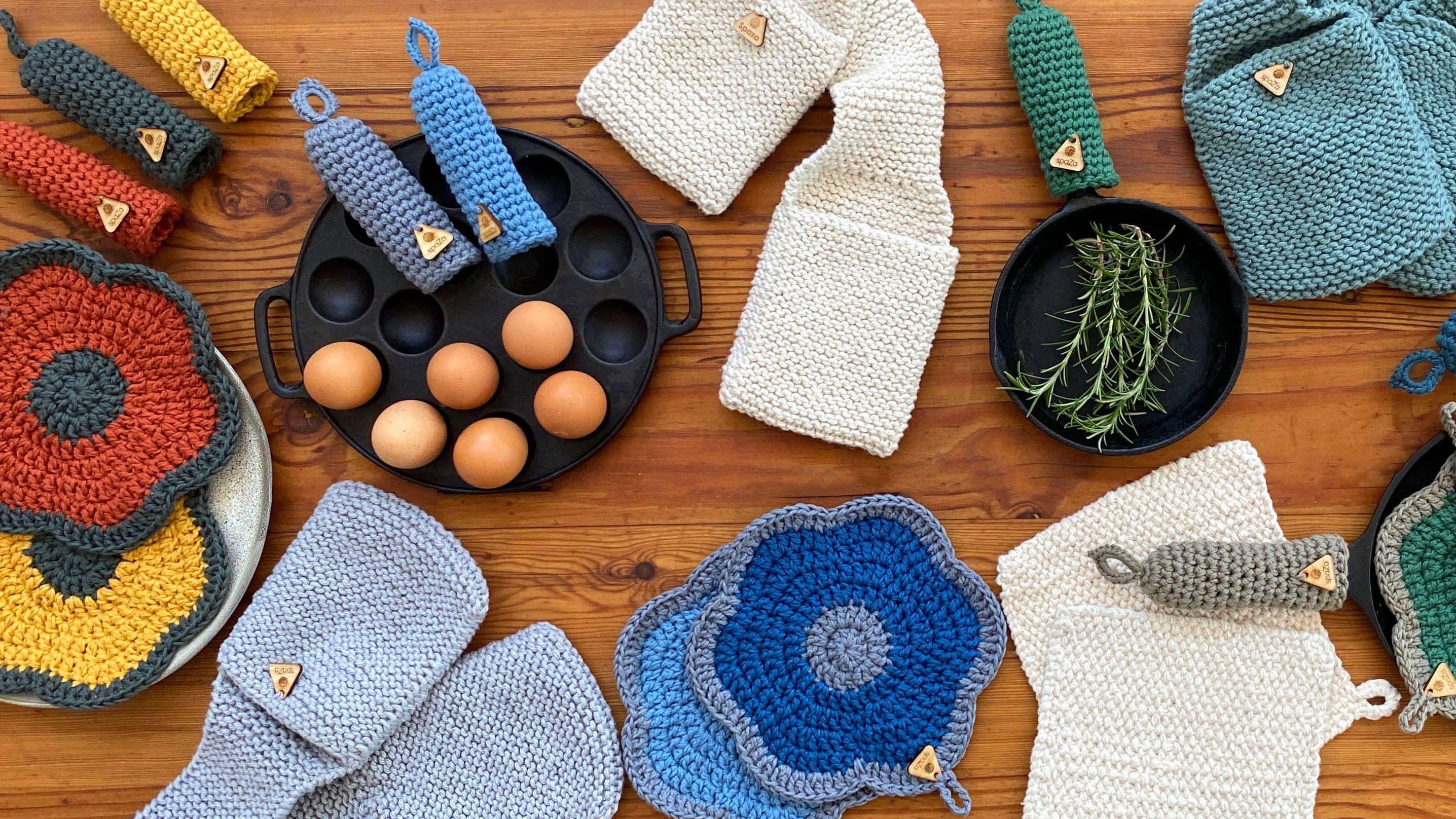 Collection of crocheted kitchen items including potholders and oven mitts on a wooden surface.